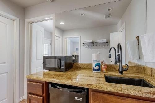 a kitchen with a sink and a microwave at 4-Bedroom Spacious Home with Guest House & Pool, Located on 9 Acres of Land in Spicewood
