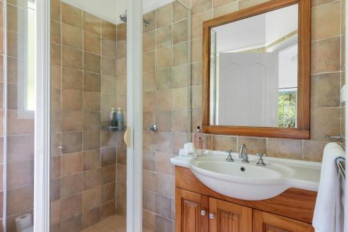a bathroom with a sink and a mirror at Alcheringa Cottage Amazing Location with views in Kangaroo Valley