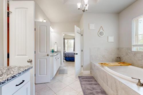 a white bathroom with a tub and a sink at Cozy Lago Vista Home with Private Pool Table, Mile From The Stunning Lake Travis in Lago Vista