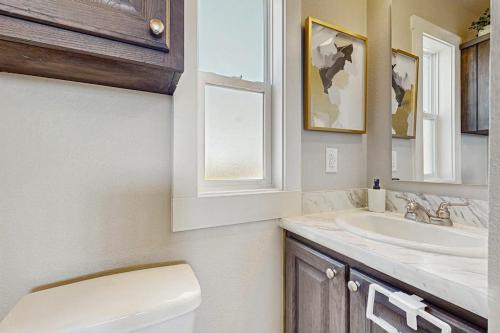 a bathroom with a sink and a toilet and a window at Modern Tiny Home with Loft, Kitchen, Cozy Patio and Shared Pools, Great Location in Fredericksburg