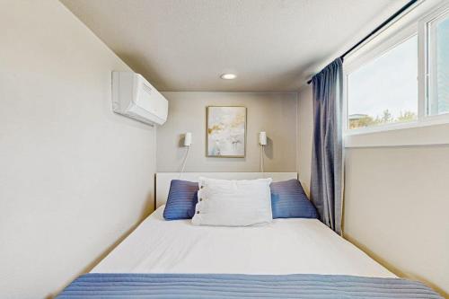 a small bedroom with a bed and a window at Modern Tiny Home with Loft, Kitchen, Cozy Patio and Shared Pools, Great Location in Fredericksburg