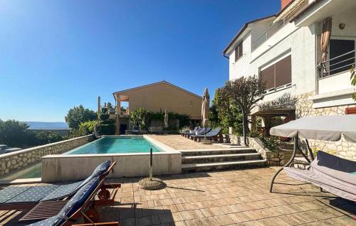a swimming pool next to a building with a house at Apartment Ravni V in Labin