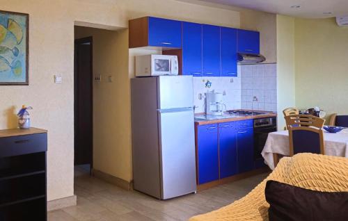 a kitchen with blue cabinets and a white refrigerator at Apartment Ravni V in Labin