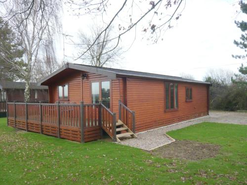 アイビーチャーチにあるCharming Cottage in Romney Marsh Britain with Wooden Deckのポーチとデッキ付きの小さなキャビン