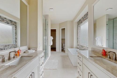 a large bathroom with two sinks and a tub at Spacious House with Ping-Pong and Pool Table, Balcony with Water and Sunset View in Point Venture