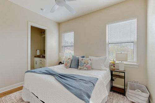 a white bedroom with a bed and a window at Spacious House with Ping-Pong and Pool Table, Balcony with Water and Sunset View in Point Venture
