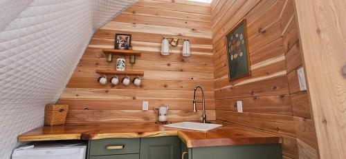 a kitchen with wooden walls and a sink at Woodland Creek in Chase