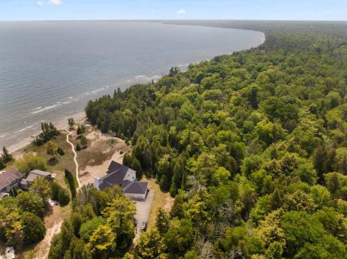 an aerial view of a house on the shore of a beach at Dune Alright by Simple Life Rentals in Baileys Harbor