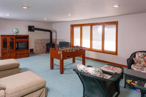 a living room with a pool table and chairs at Dune Alright by Simple Life Rentals in Baileys Harbor