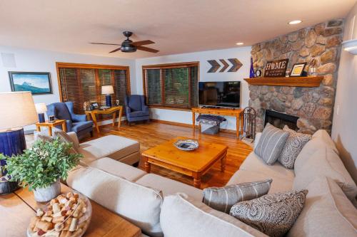 a living room with a couch and a stone fireplace at Asher Manor by Simple Life Rentals in Egg Harbor