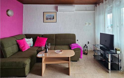 a living room with a couch and pink walls at Apartment Labin Ravni in Labin