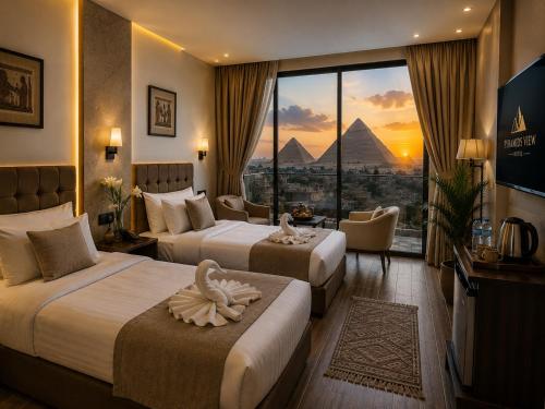 a hotel room with two beds and a view of the pyramids at Giza Pyramids view hotel in Giza