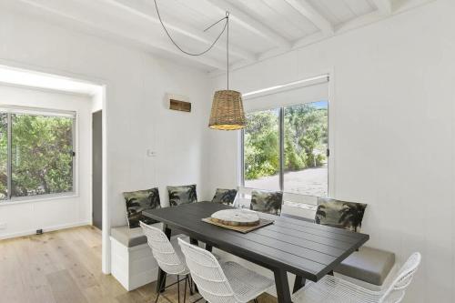 a dining room with a black table and chairs at Beach at Your Doorstep - Pet Friendly in Anglesea