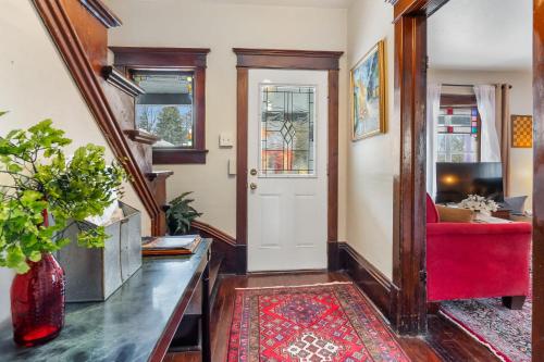 a living room with a red chair and a door at Stowaway Lower Deck in Sturgeon Bay