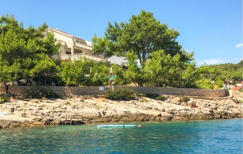 a boat in the water next to a rocky island at Villa Aqua in Vrbanj