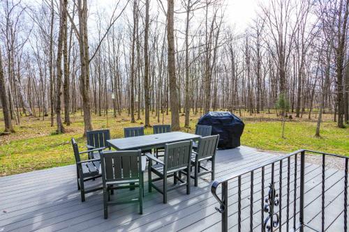 a table and chairs on a deck with trees at Grateful Roots in Egg Harbor