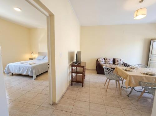 a bedroom with a bed and a living room at Departamentos Marconi 1B in Resistencia
