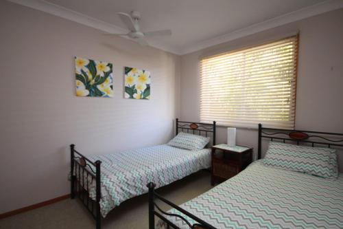 two twin beds in a room with a window at Beach Haven Villa in North Haven