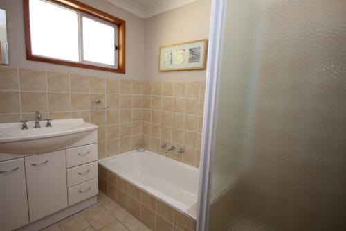 a bathroom with a tub and a sink and a shower at Beach Haven Villa in North Haven