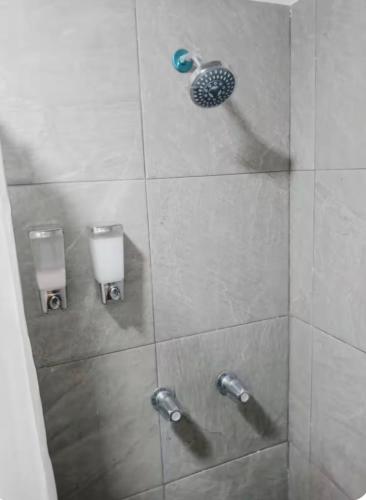 a shower with two soap dispensers in a bathroom at Consulado Americano a 5 minutos D3 in Ciudad Juárez