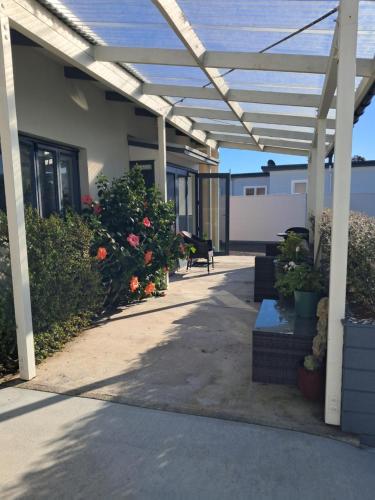 a patio with a pergola and some plants at Headlands Hotel in Opunake