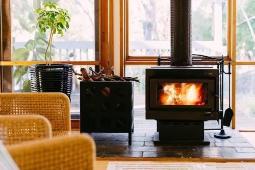 a fireplace in a living room with a fire at The Angle House - Aireys Inlet in Aireys Inlet