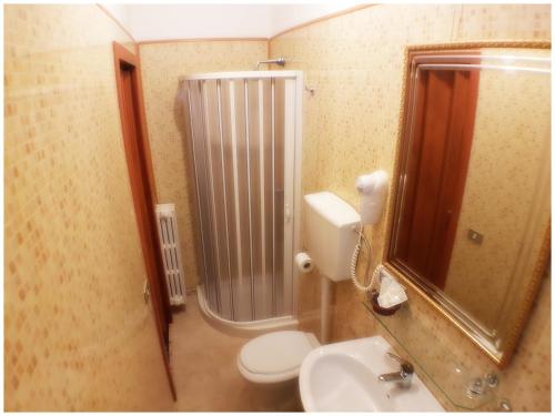 a bathroom with a shower and a toilet and a sink at Hotel Pisani in Taranto