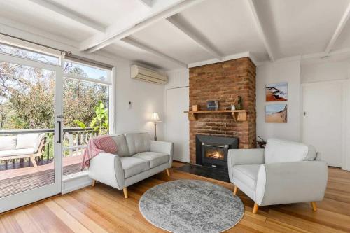a living room with two chairs and a fireplace at Sunny Coastal Retreat in Anglesea