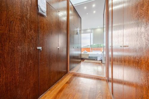 a hallway with wooden walls and a bed in a room at Keam House in Santana
