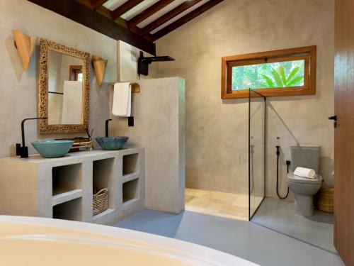 a bathroom with two sinks and a glass shower at Boarã Lodge Natureza in Pirenópolis