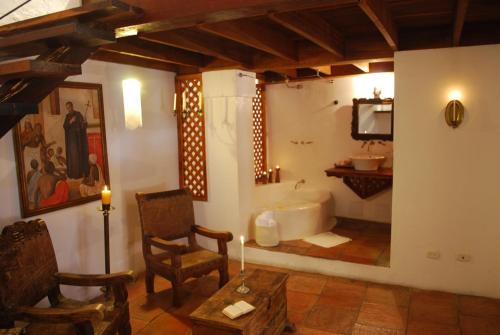 Habitación con baño con bañera y mesa. en Alfiz Hotel, en Cartagena de Indias