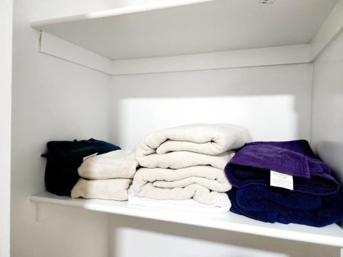 a pile of towels sitting on a shelf at Edmonton Basement 1 KB 1 SB 3 Guest in Edmonton