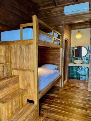 a bedroom with bunk beds in a cabin at Wavedance Bali Surfhouse in Airsatang