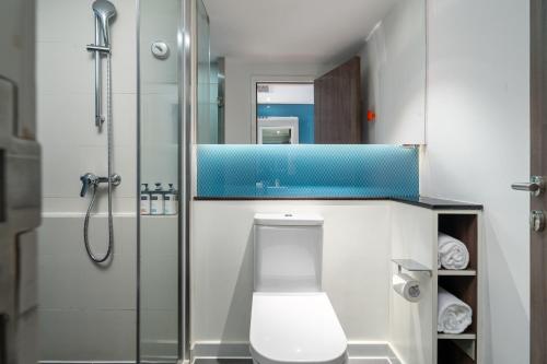 a bathroom with a toilet and a glass shower at Holiday Inn Express Xiamen LuShan in Xiamen