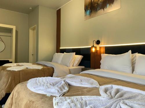 a hotel room with two beds with towels on them at Pousada HG -101-Suíte in Vila Nova do Sul