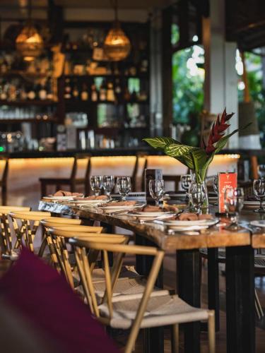 a wooden table with chairs and a vase of flowers on it at The Ronin in General Luna