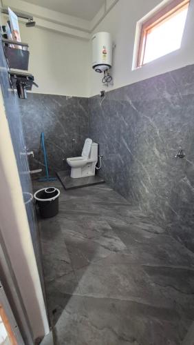 a bathroom with a toilet and a sink in a room at Ivory Nest Villa in Chamba