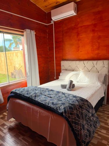 a bedroom with a bed and a window and a fan at Casa Versatil in Chuí