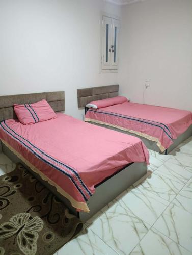 two beds sitting next to each other in a room at Holiday apartment in ‘Izbat al Waqf