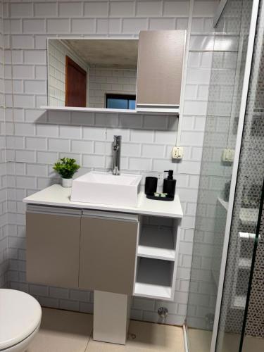 a white bathroom with a sink and a shower at Casa Versatil in Chuí