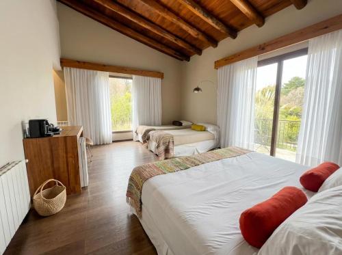 a bedroom with two beds and a large window at Posada del Blanco in Potrerillos