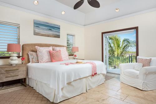 a bedroom with a bed and a chair and a window at Villa La Percha in Providenciales