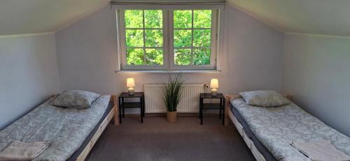 two beds in a room with a window at Sinilille 5 Holiday Home in Kuressaare