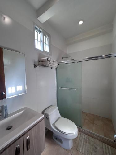 a bathroom with a toilet and a glass shower at Resort Casita in Playa Venao