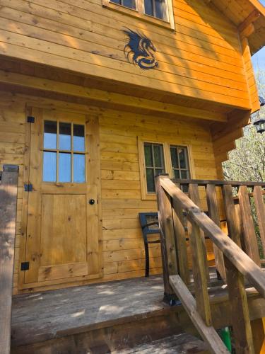 a log cabin with a porch and a door at #3 La Maison du Dragon in Saint-Onésime