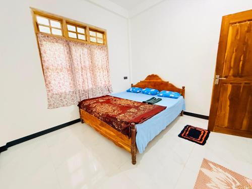 a bedroom with a bed and a window at Dew homestay in Wellawaya