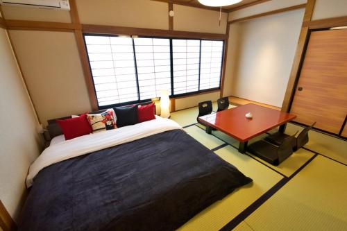 a bedroom with a large bed and a table at OKU - Nakasendo - in Shiojiri