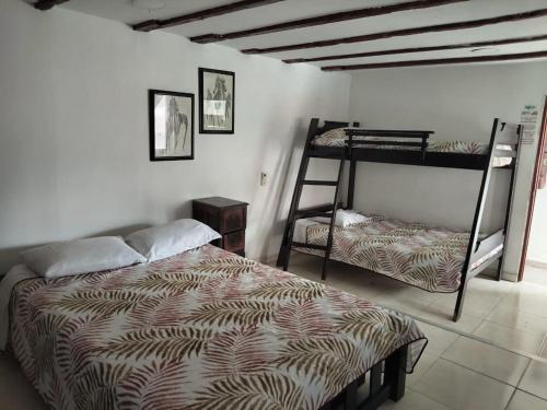 a bedroom with a bed and two bunk beds at El Hostal By Pochet in San Andrés