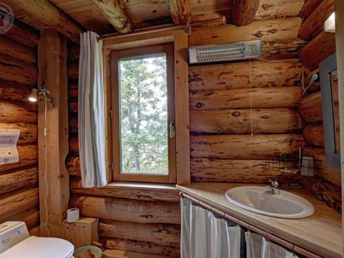 a bathroom with a sink and a window in a log cabin at Chalet rustique avec poêle à bois - 3 pers, animaux admis - FR-1-496-187 in Saint-Martin-la-Sauveté