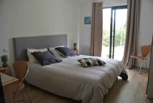 a bedroom with a large white bed with two pillows at CARPE DIEM Résidence Hôtelière in Lorgues